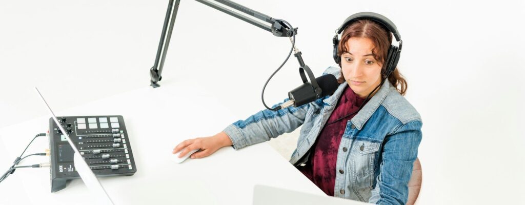 a person wearing headphones and sitting at a desk with a computer